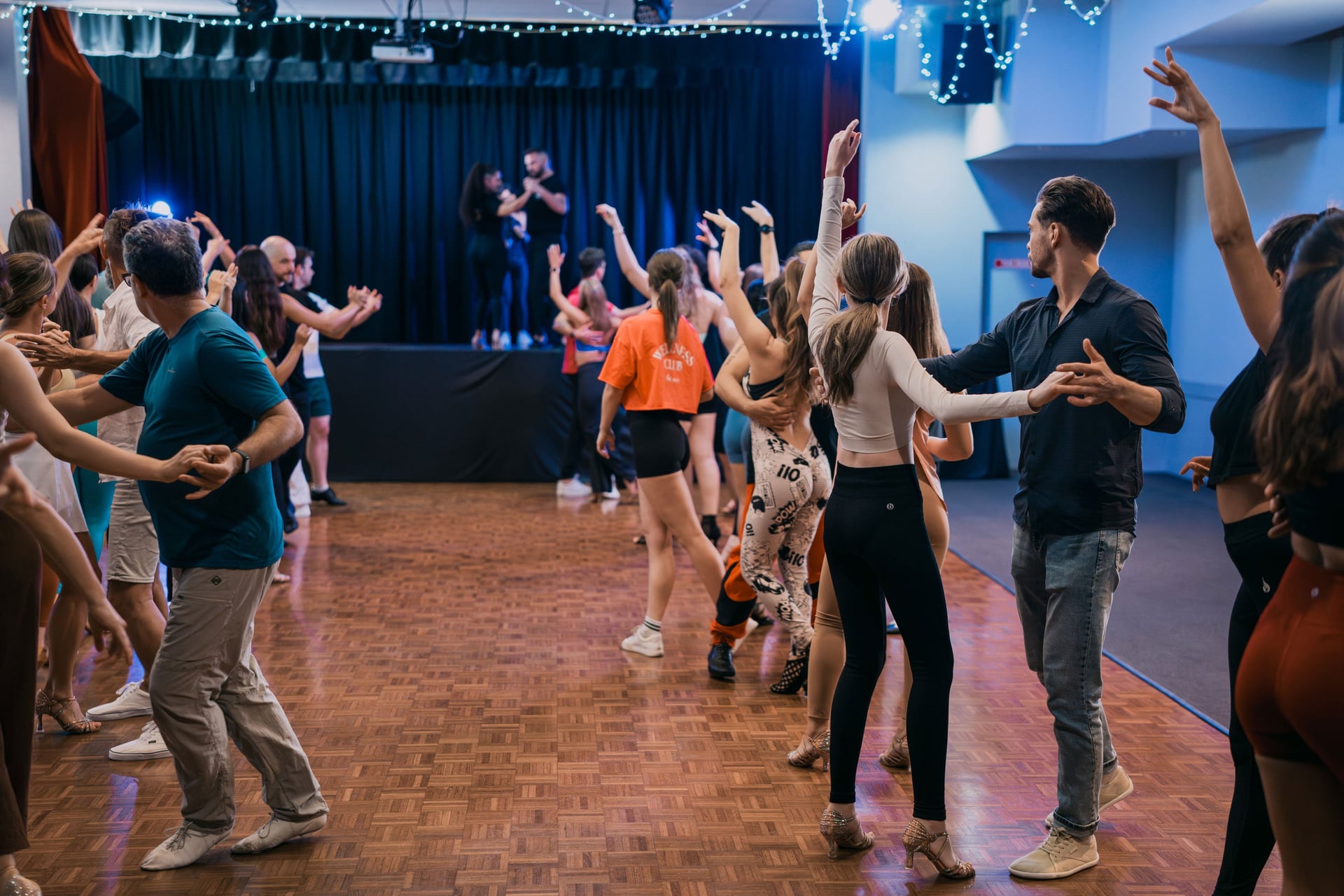 Alex and Madalyn dancing on stage in front of the class